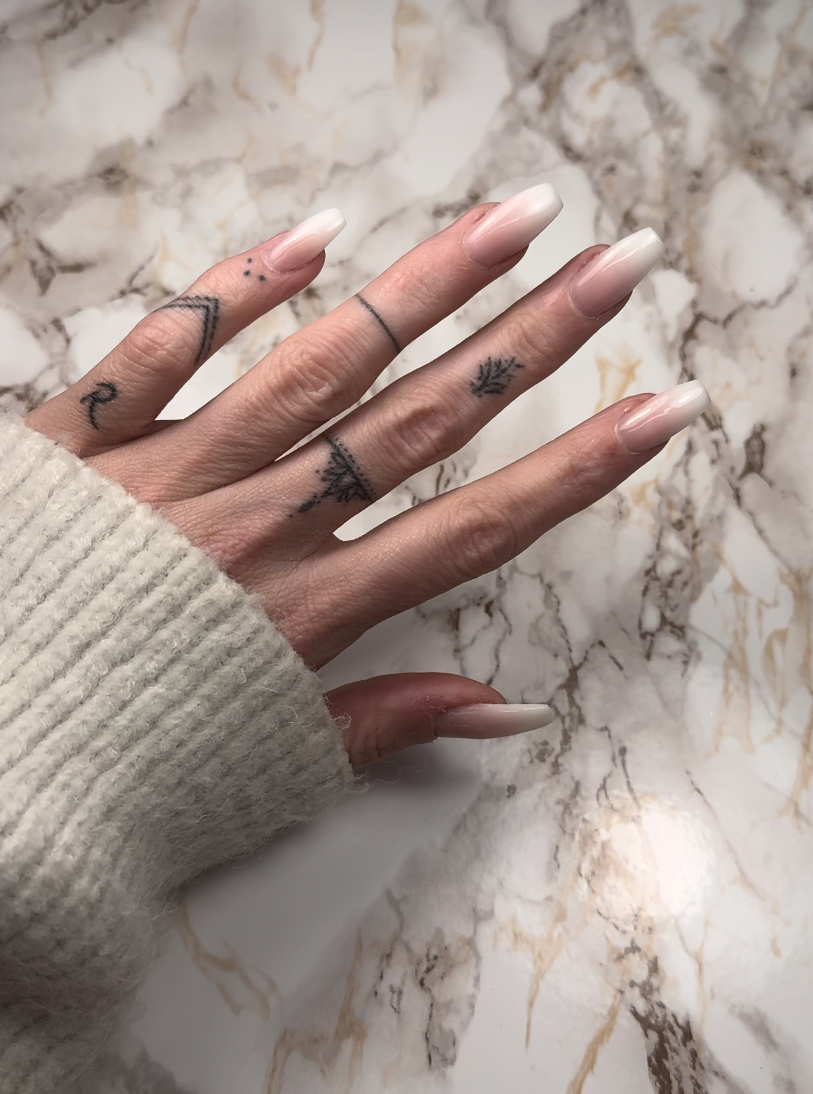 Lange nude naar wit vervagende nagels op marmer
